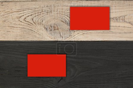 Téléchargez les photos : Cartes de visite rouges vierges sur la table en bois noir. Modèle d'identification. Vue du dessus - en image libre de droit