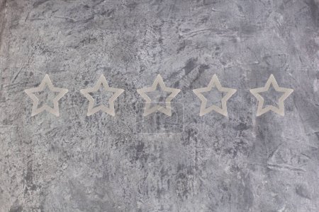 Photo for Gold, gray, silver five star shape on the gray concrete background. The best excellent business services rating customer experience concept. Concept image of setting a five star goal. Increase rating or ranking, evaluation and classification idea - Royalty Free Image