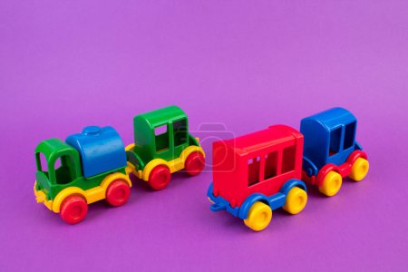 Téléchargez les photos : Jouet pour enfants, une locomotive à vapeur multicolore sur fond violet - en image libre de droit