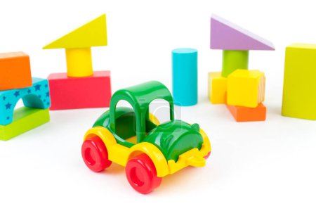 Foto de Juguetes para niños, coche multicolor, cubos de constructor de madera sobre un fondo blanco - Imagen libre de derechos