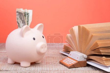 Photo for Piggy bank in glasses and books on Orange background. open book. Tuition payment. Brainwork. Typewriter. The concept of literary creativity - Royalty Free Image