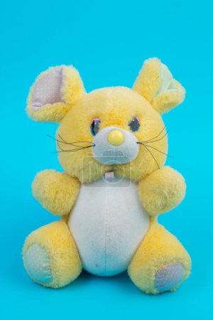 Téléchargez les photos : Peluche jouet souris jaune sur fond bleu - en image libre de droit