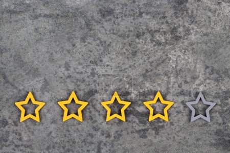Photo for Gold, gray, silver five stars shape on the gray concrete background. The best excellent business services rating customer experience concept. Concept image of setting a five star goal. Increase rating or ranking, evaluation and classification idea - Royalty Free Image