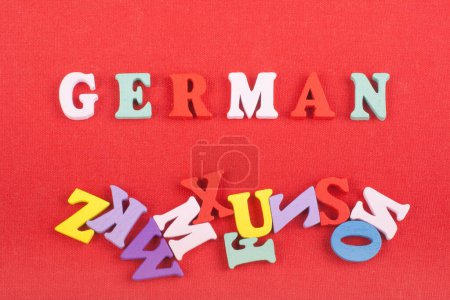 Photo for German word on red background composed from colorful abc alphabet block wooden letters, copy space for ad text. Learning english concept - Royalty Free Image