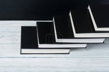 Foto de Libros abiertos en blanco y negro sobre mesa de madera, fondo de pizarra negra. De vuelta a la escuela. Concepto de negocio educativo - Imagen libre de derechos