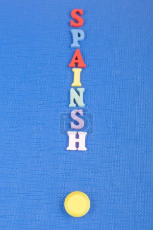 Foto de ESPAÑA palabra sobre fondo azul compuesta de letras de madera abc bloque alfabeto colorido, espacio de copia para el texto del anuncio. Aprender el concepto inglés - Imagen libre de derechos