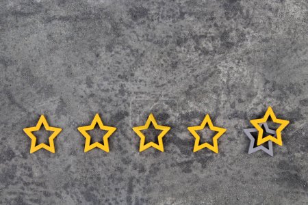Photo for Gold, gray, silver five stars shape on the gray concrete background. The best excellent business services rating customer experience concept. Concept image of setting a five star goal. Increase rating or ranking, evaluation and classification idea - Royalty Free Image