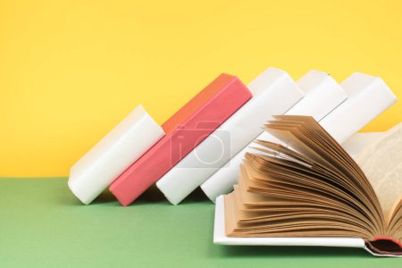 Photo for Book stacking. Open hardback books on wooden table and green background. Back to school. Copy space for ad text - Royalty Free Image