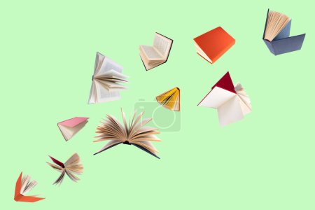 Foto de Libros coloridos de tapa dura volando aislados sobre fondo verde - Imagen libre de derechos