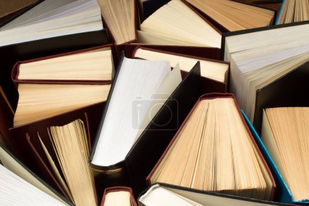 Photo for Old and used hardback books or text books seen from above. Books and reading are essential for self improvement, gaining knowledge and success in our careers, business and personal lives - Royalty Free Image