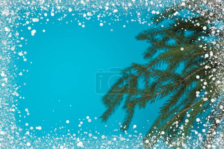 Foto de Composición navideña de ramas de abeto y bayas de viburnum sobre un fondo azul aislado - Imagen libre de derechos