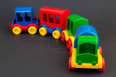 Foto de Juguete infantil, una locomotora de vapor multicolor sobre un fondo negro. Para el desarrollo del niño. - Imagen libre de derechos