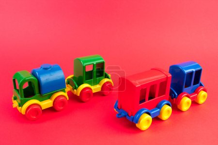 Téléchargez les photos : Jouet pour enfants, une locomotive à vapeur multicolore sur fond rede. Pour le développement de l'enfant. - en image libre de droit