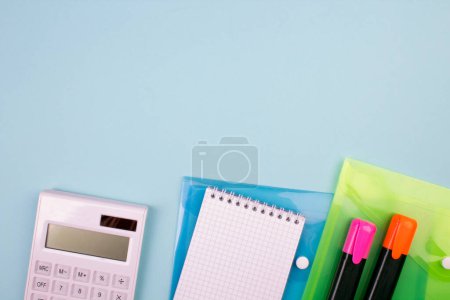 Photo for Tablet, calculator, phone, pen and a cup of coffee, lot of things on a blue background. Top view with copy space - Royalty Free Image