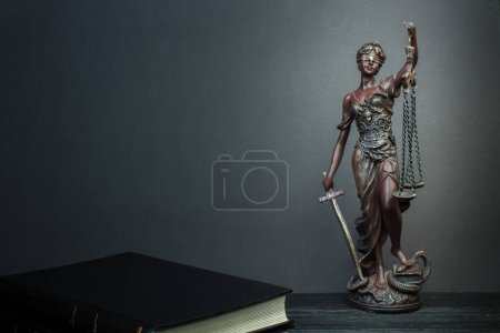 Photo for Themis and books on jurisprudence on a wooden background. Legal and law concept - Royalty Free Image