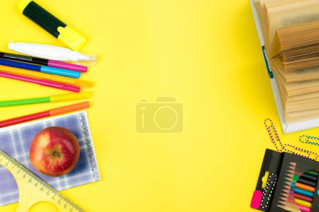 Téléchargez les photos : Je retourne à l'école. Papeterie sur une table jaune. Bureau avec espace de copie. Pose plate - en image libre de droit