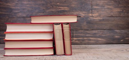 Photo for Composition with hardback books, fanned pages on wooden deck table and background. Books stacking. Back to school. Copy Space. Education background - Royalty Free Image