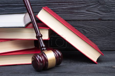 Photo for Law concept - Open law book with a wooden judges gavel on table in a courtroom or law enforcement office on blue background. Copy space for text - Royalty Free Image