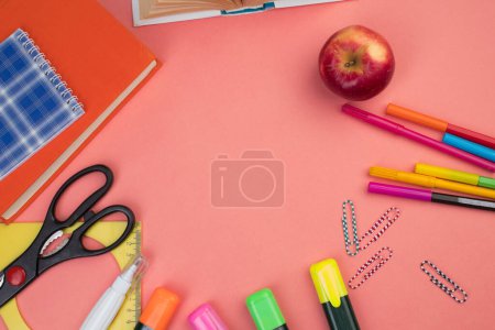 Foto de De vuelta a la escuela. Papelería sobre una mesa de color salmón. Escritorio de oficina con espacio para copias. Puesta plana - Imagen libre de derechos
