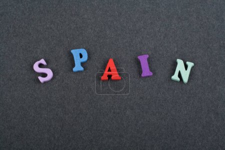Photo for SPANISH word on black board background composed from colorful abc alphabet block wooden letters, copy space for ad text. Learning english concept - Royalty Free Image