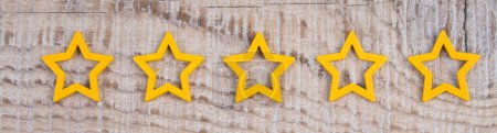 Photo for Gold, gray, silver five stars shape on wooden background. The best excellent business services rating customer experience concept. Increase rating or ranking, evaluation and classification idea - Royalty Free Image