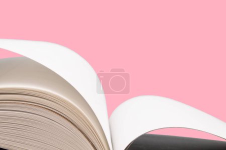 Photo for Open book. Composition with hardback books, fanned pages on wooden deck table and pink background. Books stacking. Back to school. Copy Space. Education background. Tuition payment. - Royalty Free Image