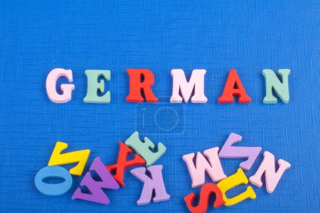 Téléchargez les photos : Mot allemand sur fond bleu composé de lettres en bois de bloc alphabet abc coloré, espace de copie pour le texte de l'annonce. Apprendre le concept anglais - en image libre de droit