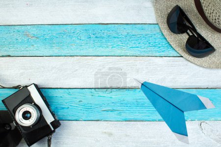 Téléchargez les photos : Chapeau, appareil photo, sac, lunettes, crème solaire sur un fond en bois d'été. Vue du dessus et espace de copie - en image libre de droit