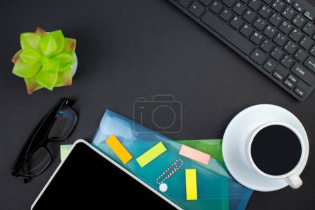 Foto de Mesa de oficina negro con computadora, bolígrafo y una taza de café, muchas cosas. Vista superior con espacio de copia - Imagen libre de derechos