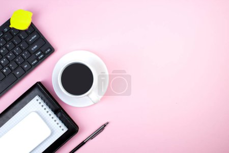 Téléchargez les photos : Table de bureau rose avec ordinateur, stylo et une tasse de café, beaucoup de choses. Vue supérieure avec espace de copie - en image libre de droit
