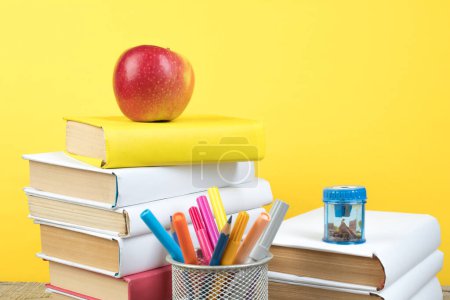 Photo for Books stacking. Books on wooden table and yellow background. Back to school. Copy space for ad text - Royalty Free Image