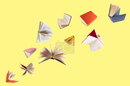 Foto de Libros coloridos de tapa dura volando aislados sobre fondo amarillo - Imagen libre de derechos