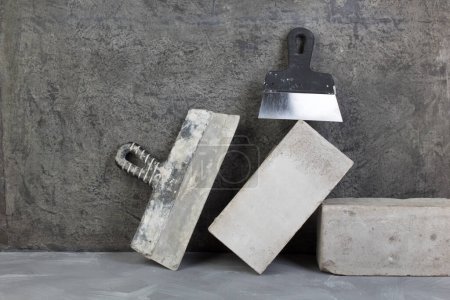 Photo for Bricks, putty knife on the gray concrete background. Copy space. Top view - Royalty Free Image