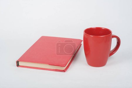 Téléchargez les photos : Livre rouge et tasse sur une table blanche - en image libre de droit