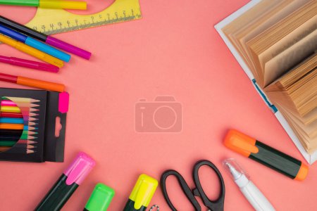 Photo for Back to school. Stationery on a salmon color table. Office desk with copy space. Flat lay - Royalty Free Image