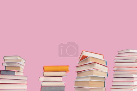 Téléchargez les photos : Composition avec des livres à dos rigide sur table de pont en bois et fond rose. Des livres empilés. Je retourne à l'école. Espace de copie. Formation initiale. - en image libre de droit