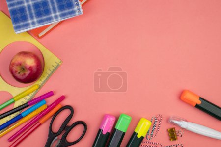 Foto de De vuelta a la escuela. Papelería sobre una mesa de color salmón. Escritorio de oficina con espacio para copias. Puesta plana - Imagen libre de derechos