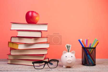 Photo for Composition with hardback books, fanned pages on wooden deck table and orange background. Books stacking. Back to school. Copy Space. Education background. Tuition payment. - Royalty Free Image