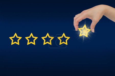 Photo for Woman's hand put the stars to complete five stars. Customer satisfaction concept. copy space and blue background. giving a five star rating. Service rating, satisfaction concept - Royalty Free Image