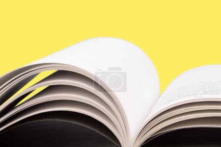 Photo for Open book. Composition with hardback books, fanned pages on wooden deck table and yellow background. Books stacking. Back to school. Copy Space. Education background. Tuition payment. - Royalty Free Image