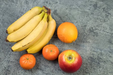 Foto de Frutas. Plátanos, manzanas, naranjas mandarinas sobre un fondo bitón - Imagen libre de derechos