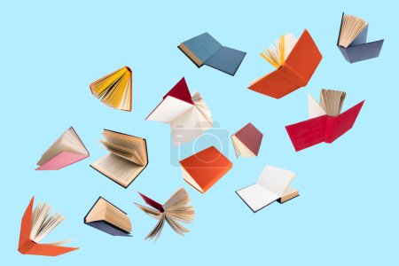 Photo for Colorful hardcover books flying isolated on blue background - Royalty Free Image