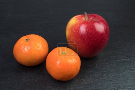 Foto de Frutas. Manzanas, naranjas mandarinas sobre fondo negro - Imagen libre de derechos