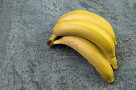 Téléchargez les photos : Un paquet de bananes sur fond de biton. Vue du dessus - en image libre de droit