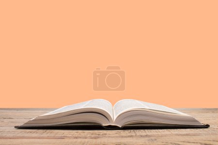 Photo for Open book. Composition with hardback books, fanned pages on wooden deck table and orange background. Books stacking. Back to school. Copy Space. Education background - Royalty Free Image