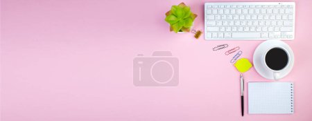 Téléchargez les photos : Table de bureau rose avec ordinateur, stylo et une tasse de café, beaucoup de choses. Vue supérieure avec espace de copie, Bannière - en image libre de droit