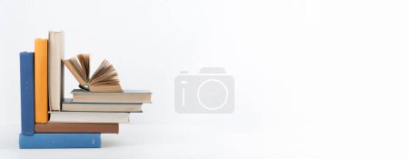 Foto de Libro abierto, libros de colores sobre mesa de madera, fondo blanco. De vuelta a la escuela. Copia espacio para texto. Concepto de negocio de educación, Banner - Imagen libre de derechos