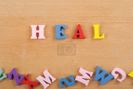 Photo for HEAL word on wooden background composed from colorful abc alphabet block wooden letters, copy space for ad text. Learning english concept - Royalty Free Image