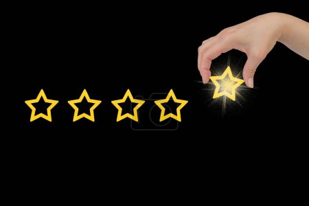 Photo for Woman's hand put the stars to complete five stars. Customer satisfaction concept. copy space and the background of the blackboard. giving a five star rating. Service rating, satisfaction concept - Royalty Free Image