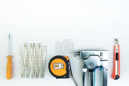 Foto de Taladro, cuchillo de masilla, destornilladores grapadora de construcción sobre fondo blanco. Herramienta. Vista superior - Imagen libre de derechos